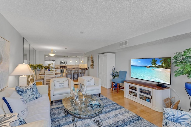 1460 Gulf Blvd Unit 406, Clearwater Beach, FL 33767 - living area featuring visible vents, light wood-style floors, and a textured ceiling