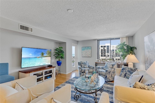 1460 Gulf Blvd Unit 406, Clearwater Beach, FL 33767 - living area with visible vents, baseboards, light wood-style floors, and a textured ceiling