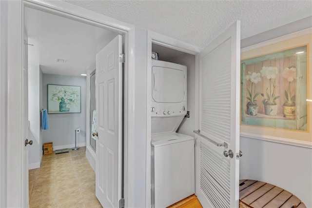 1460 Gulf Blvd Unit 406, Clearwater Beach, FL 33767 - laundry area featuring laundry area, stacked washer and clothes dryer, light tile patterned floors, and a textured ceiling