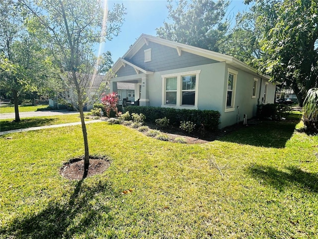 view of front facade with a front yard and stucco siding