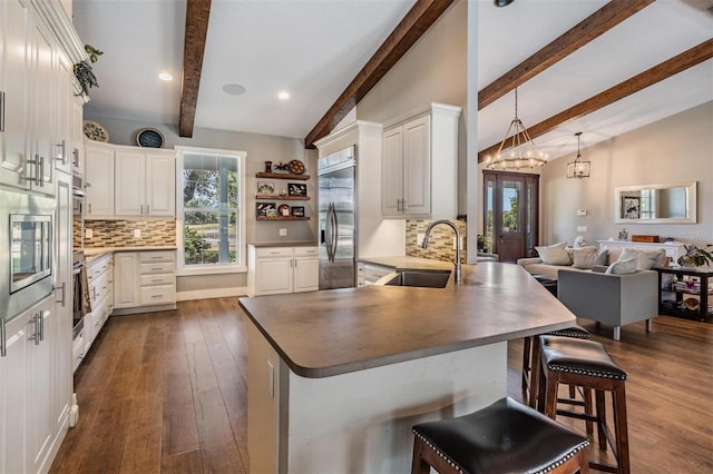25601 Hutcheson Ln, Sorrento, FL 32776 - kitchen with dark wood finished floors, vaulted ceiling with beams, built in appliances, a sink, and a peninsula