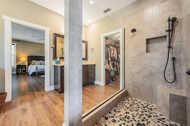 25601 Hutcheson Ln, Sorrento, FL 32776 - full bathroom featuring connected bathroom, a tile shower, visible vents, and wood finished floors