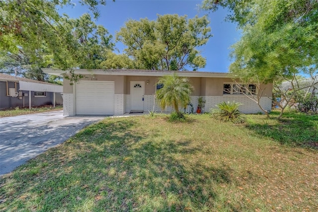 ranch-style home with concrete driveway, stucco siding, a front lawn, an attached garage, and brick siding