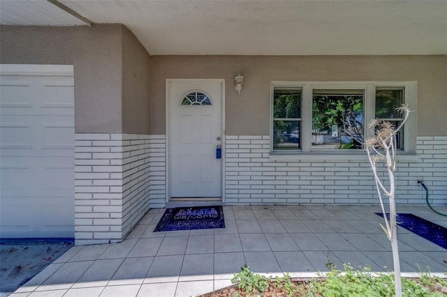 doorway to property featuring brick siding and stucco siding