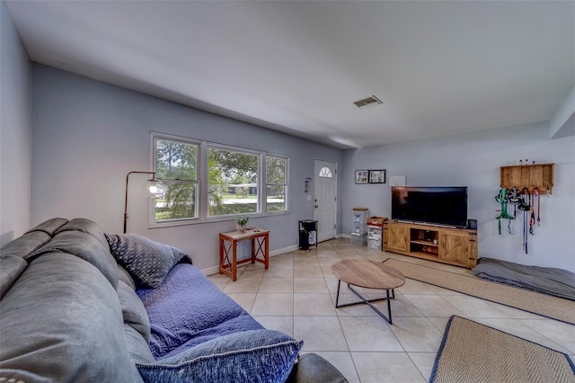 living area featuring tile patterned flooring, visible vents, and baseboards