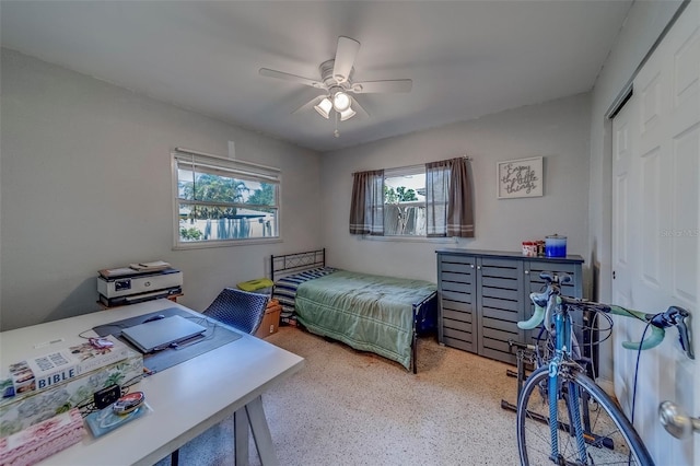 bedroom with a closet, speckled floor, and ceiling fan
