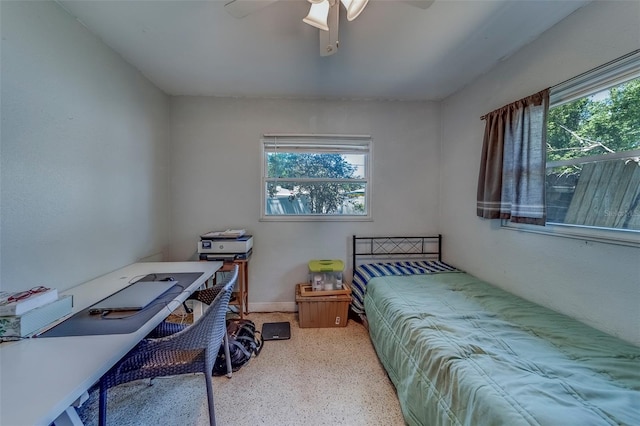 bedroom with a ceiling fan, speckled floor, baseboards, and multiple windows