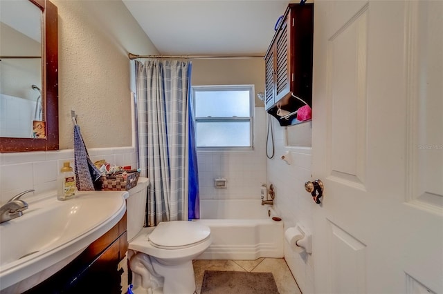 bathroom featuring shower / bathtub combination with curtain, vanity, tile patterned flooring, toilet, and tile walls