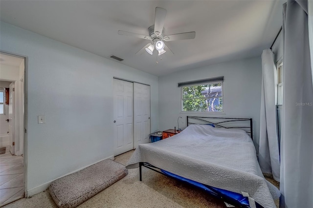 bedroom with a closet, ceiling fan, baseboards, and visible vents