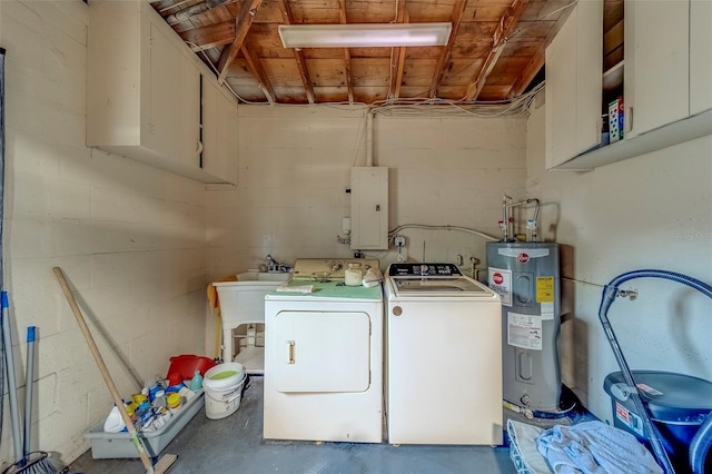 washroom featuring electric water heater, electric panel, washer and clothes dryer, cabinet space, and concrete block wall