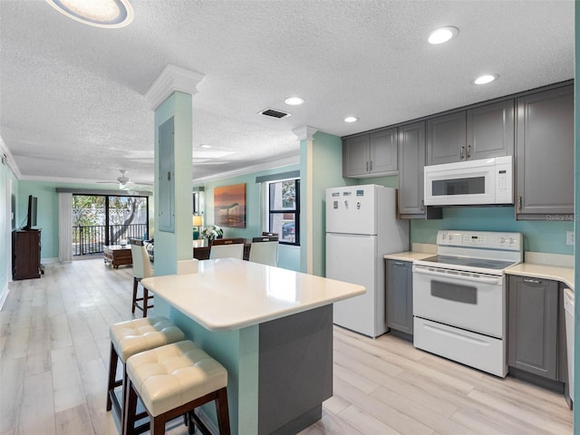 kitchen with gray cabinetry, white appliances, light countertops, and open floor plan