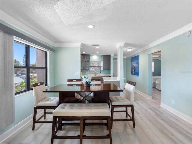 dining area featuring baseboards, a textured ceiling, crown molding, recessed lighting, and light wood-style flooring
