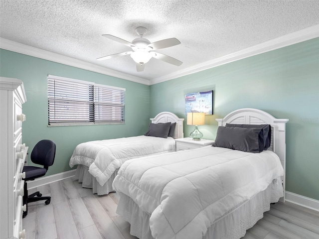 bedroom with crown molding, baseboards, light wood-style floors, and a textured ceiling