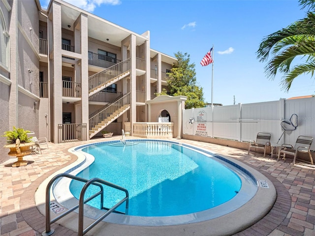 community pool featuring a patio area and fence