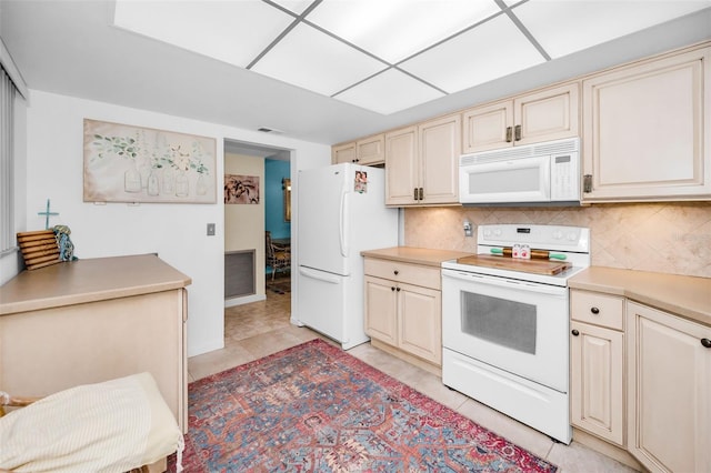5108 Brittany Dr S Unit 607, Saint Petersburg, FL 33715 - kitchen with white appliances, cream cabinets, backsplash, and light tile patterned floors