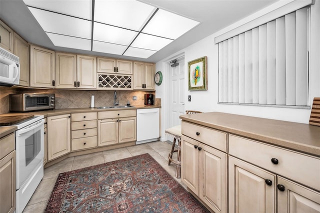 5108 Brittany Dr S Unit 607, Saint Petersburg, FL 33715 - kitchen with white appliances, a sink, decorative backsplash, and light tile patterned floors