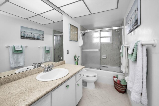 5108 Brittany Dr S Unit 607, Saint Petersburg, FL 33715 - bathroom with vanity, tile patterned floors, shower / bath combination with glass door, and toilet