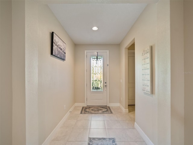 doorway featuring light tile patterned flooring and baseboards