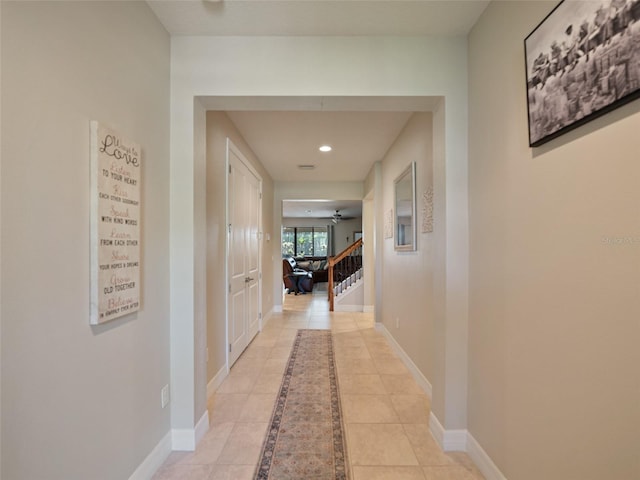 hall with light tile patterned floors, baseboards, and recessed lighting
