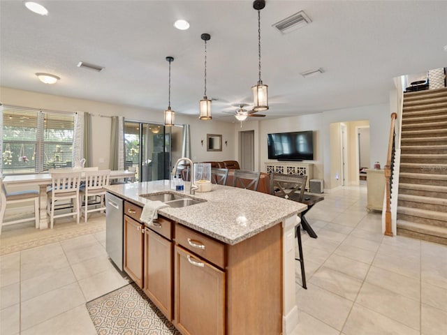 kitchen with visible vents, a sink, ceiling fan, brown cabinetry, and stainless steel dishwasher