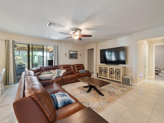 tiled living area featuring visible vents, a textured ceiling, baseboards, and ceiling fan