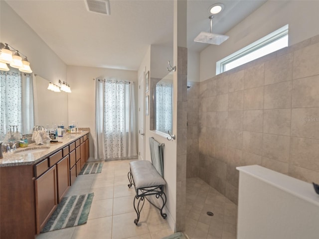 full bath featuring a walk in shower, tile patterned flooring, visible vents, a sink, and double vanity