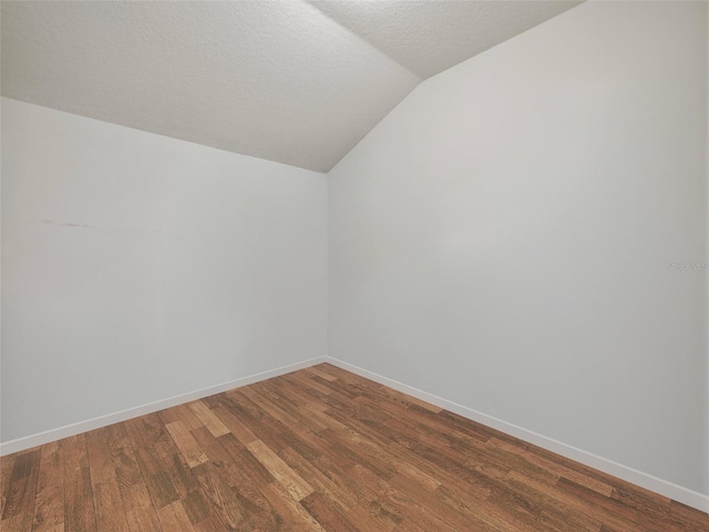 bonus room featuring baseboards, a textured ceiling, wood finished floors, and lofted ceiling