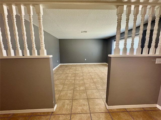 spare room featuring light tile patterned floors and baseboards