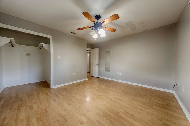 unfurnished bedroom featuring light wood-style flooring, baseboards, a ceiling fan, and a closet
