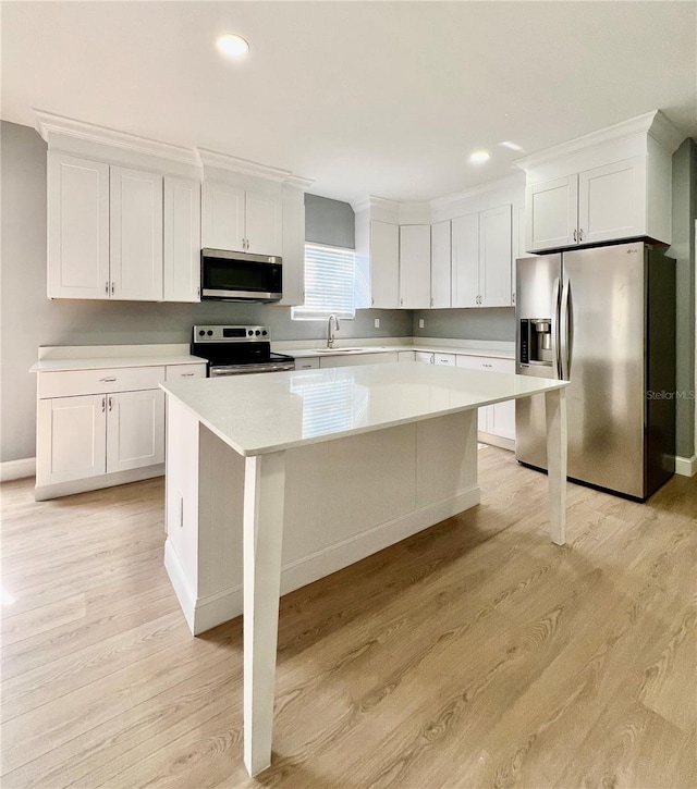 1002 E N Bay St, Tampa, FL 33603 - kitchen with stainless steel appliances, a center island, light countertops, white cabinets, and recessed lighting