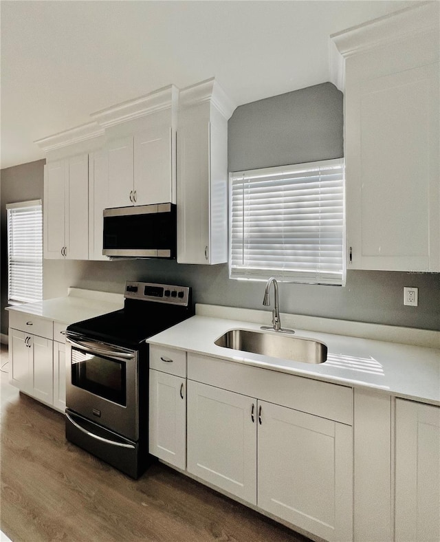 1002 E N Bay St, Tampa, FL 33603 - kitchen with stainless steel appliances, a sink, dark wood-type flooring, and white cabinets