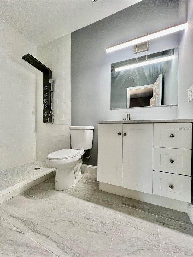 1002 E N Bay St, Tampa, FL 33603 - bathroom featuring vanity, toilet, a stall shower, marble look tiles, and baseboards