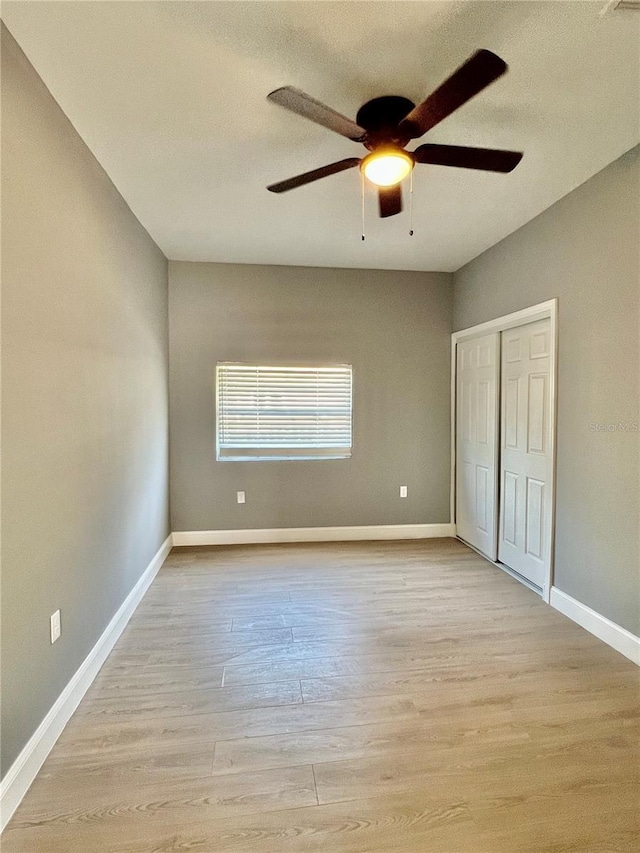 1002 E N Bay St, Tampa, FL 33603 - unfurnished bedroom featuring light wood-style floors, a closet, baseboards, and a ceiling fan