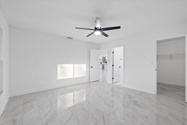 4175 N Concord Dr, Crystal River, FL 34428 - unfurnished bedroom with baseboards, a walk in closet, visible vents, ceiling fan, and marble finish floor