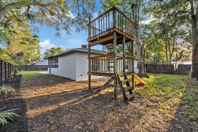 4175 N Concord Dr, Crystal River, FL 34428 - rear view of property with a fenced backyard, a playground, a wooden deck, and stucco siding