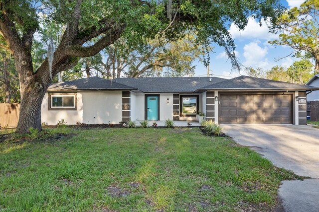 4175 N Concord Dr, Crystal River, FL 34428 - ranch-style home with a front yard, an attached garage, fence, stucco siding, and driveway