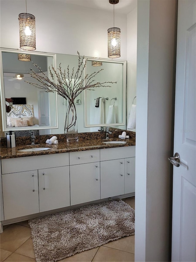 ensuite bathroom featuring a sink, ensuite bathroom, double vanity, and tile patterned flooring