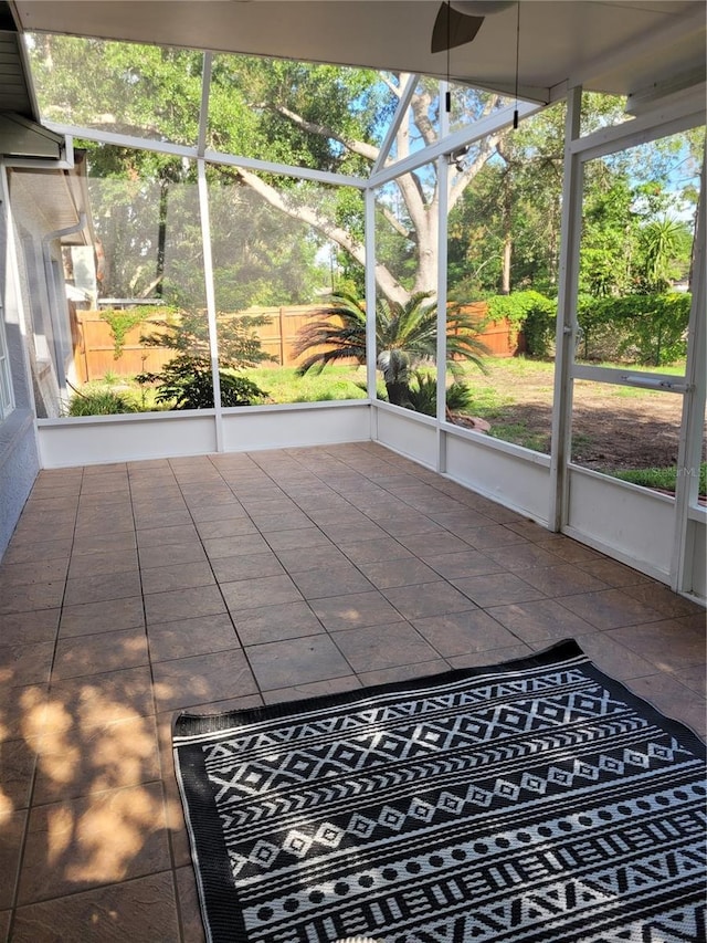 unfurnished sunroom with a ceiling fan