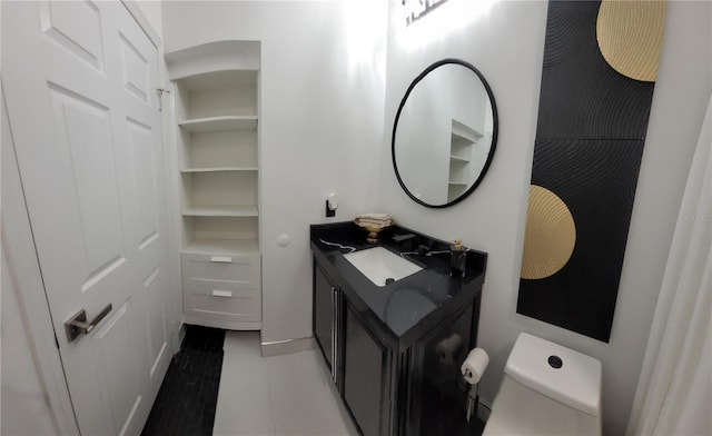 half bathroom featuring toilet, vanity, and tile patterned floors