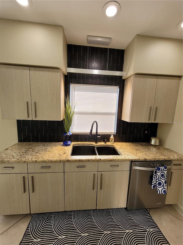 kitchen with a sink, stainless steel dishwasher, and light brown cabinetry