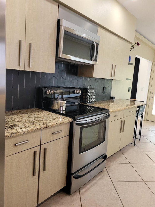 824 Greenbelt Cir, Brandon, FL 33510 - kitchen with appliances with stainless steel finishes, decorative backsplash, light stone counters, and light tile patterned floors