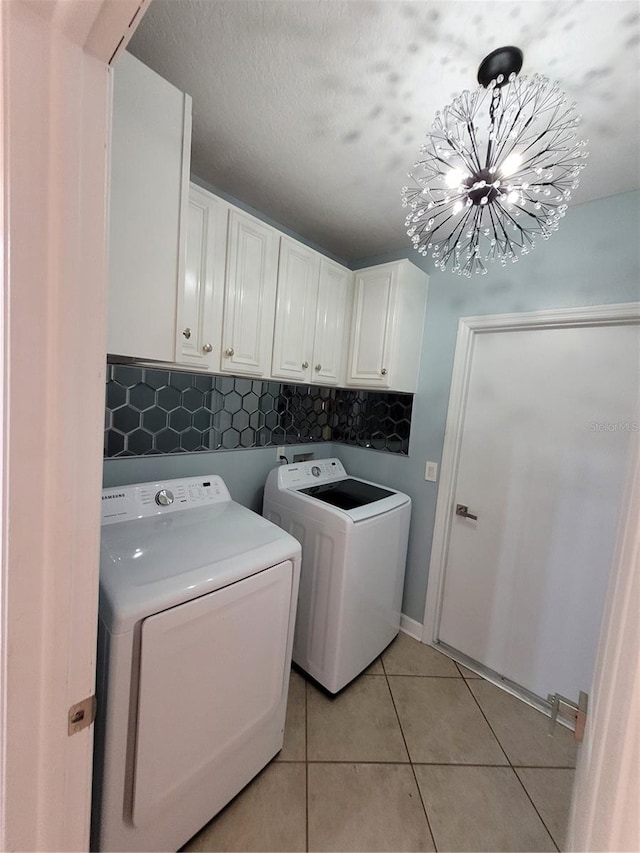 824 Greenbelt Cir, Brandon, FL 33510 - washroom with cabinet space, washing machine and clothes dryer, light tile patterned floors, and a chandelier
