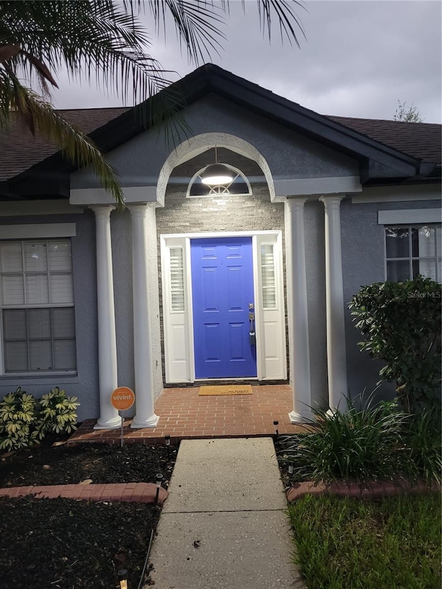 824 Greenbelt Cir, Brandon, FL 33510 - view of exterior entry featuring stucco siding and roof with shingles