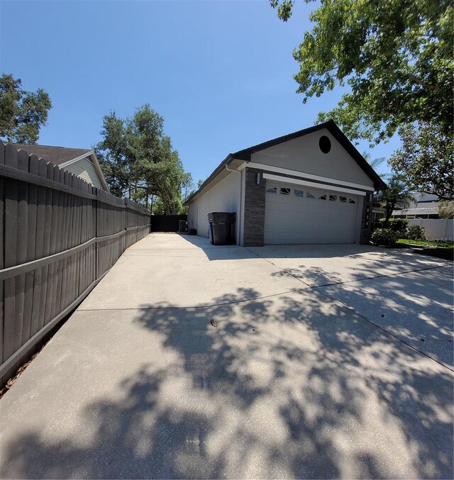 824 Greenbelt Cir, Brandon, FL 33510 - view of side of property with concrete driveway, an attached garage, and stucco siding