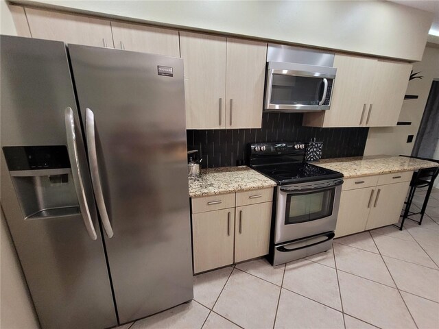 824 Greenbelt Cir, Brandon, FL 33510 - kitchen featuring stainless steel appliances, backsplash, light tile patterned floors, and light stone counters