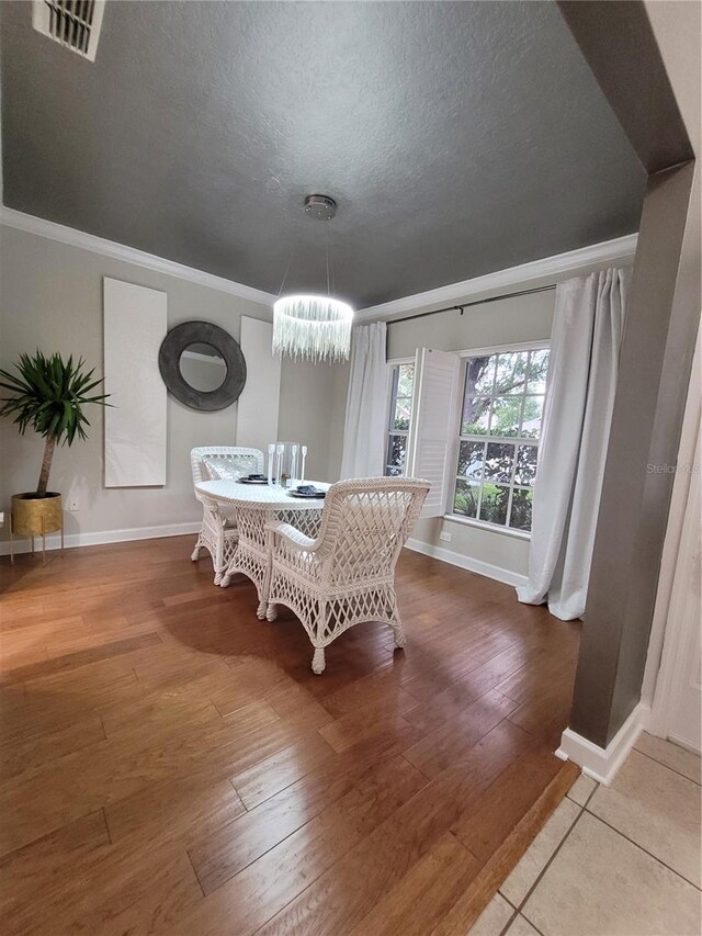 824 Greenbelt Cir, Brandon, FL 33510 - dining room featuring crown molding, a chandelier, wood-type flooring, and a textured ceiling