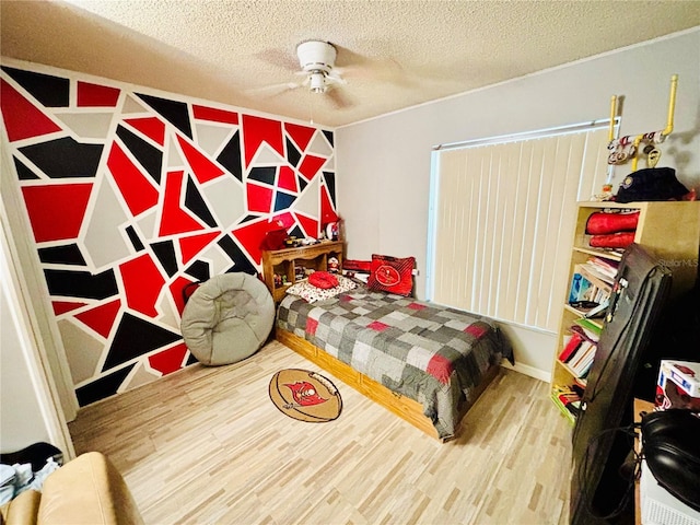 bedroom with a textured ceiling and wood finished floors