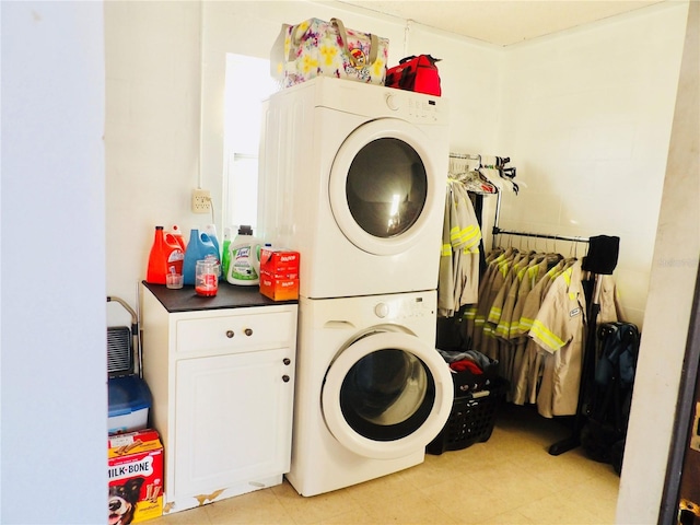clothes washing area featuring light tile patterned floors and stacked washer / drying machine