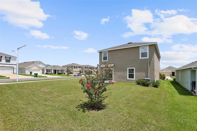 7530 Broad Pointe Dr, Zephyrhills, FL 33540 - rear view of house with a residential view, stucco siding, a lawn, and concrete driveway