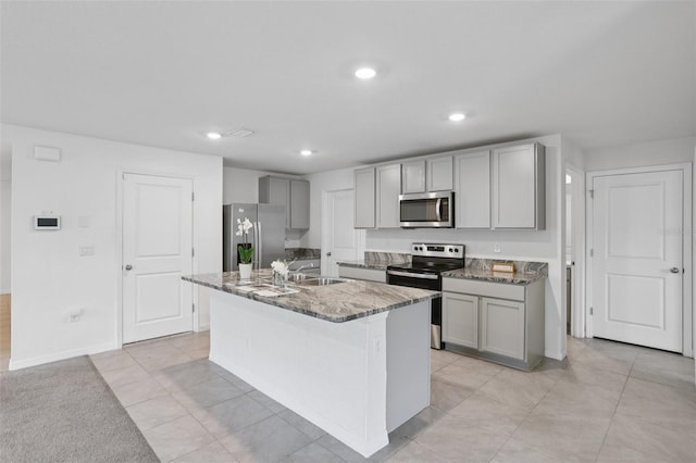 7530 Broad Pointe Dr, Zephyrhills, FL 33540 - kitchen featuring stainless steel appliances, gray cabinetry, stone countertops, a kitchen island with sink, and recessed lighting
